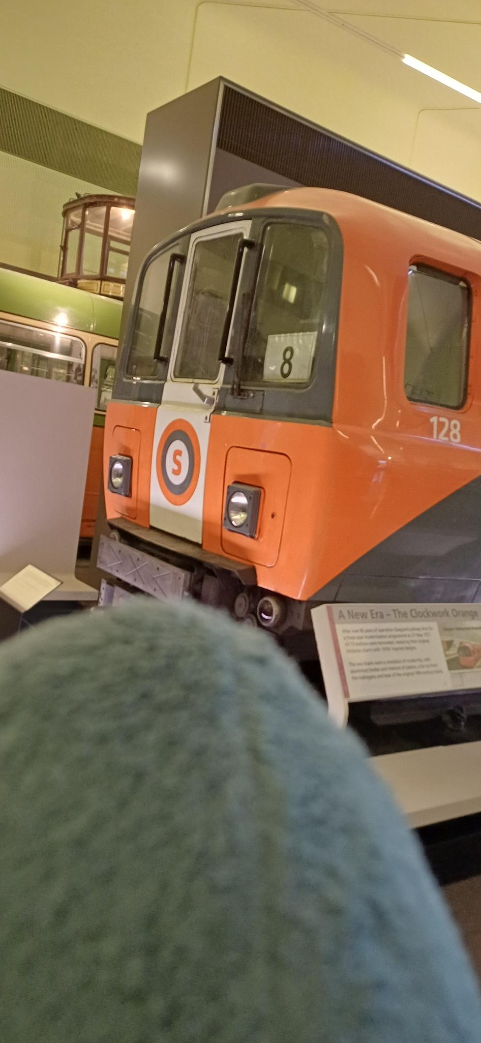 Hajco looking at an old Glasgow subway carriage. It has an orange and grey livery